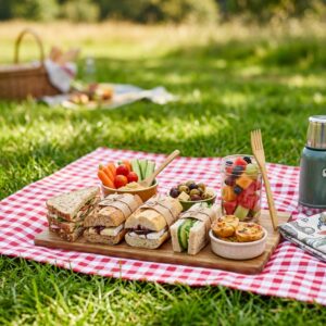 Sandwiches et plats de pique-nique disposés sur une nappe champêtre