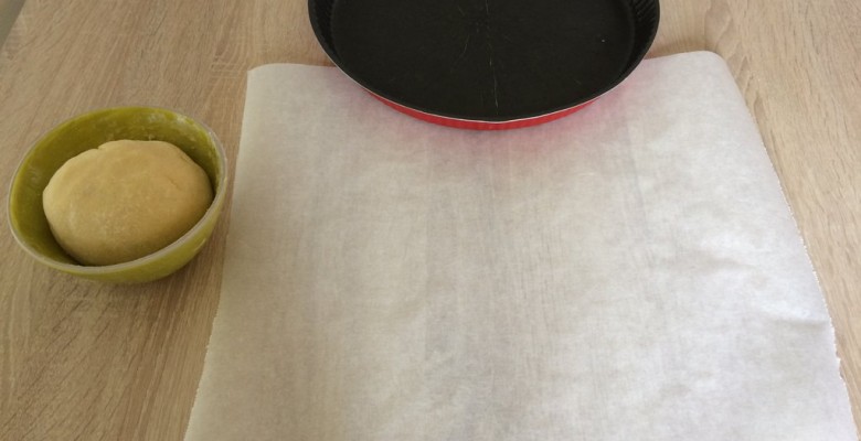 Pour étaler la pâte, découpe un carré de feuille de papier sulfurisé (plus grand que le diamètre de ton moule)
