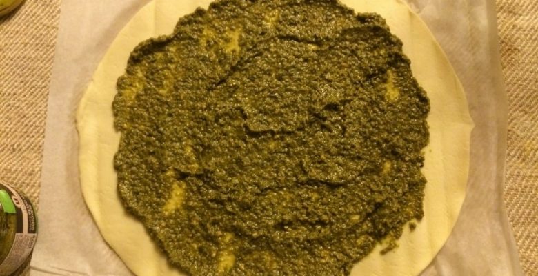 Étale le pesto sur la pâte. Laisse 2 cm sans pesto sur les bords.