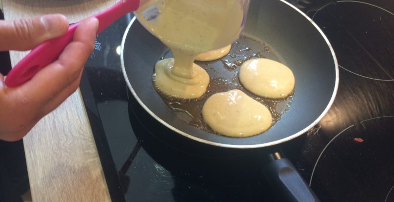 Verse de petits tas de pâte à pancake dans la poêle bien chaude