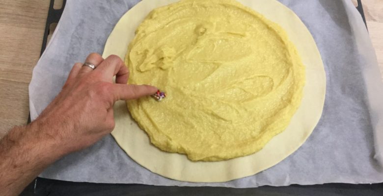 Ajoute la fève sur un côté de la pâte.